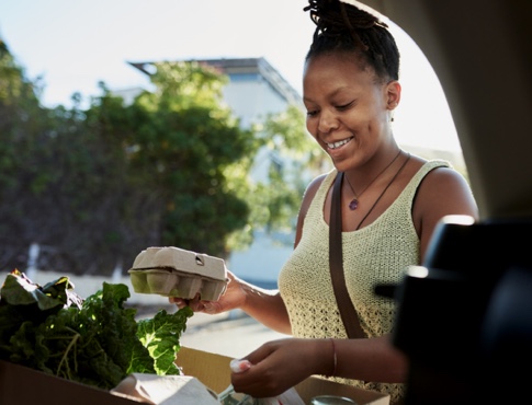 Young woman putting groceries in the car