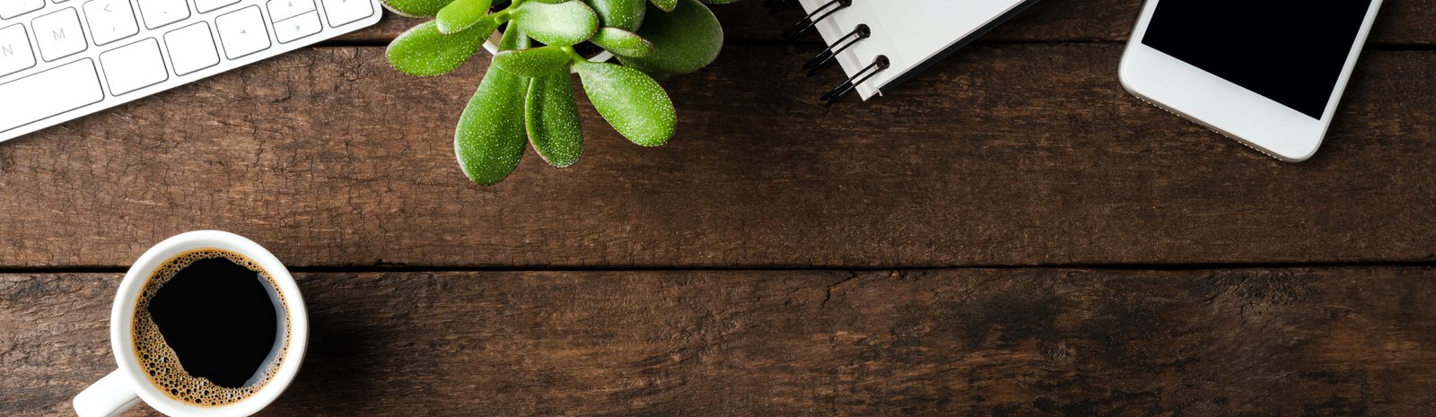 Top view of desk with coffee, plant, and technology