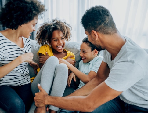 Family of four laughing on a couch